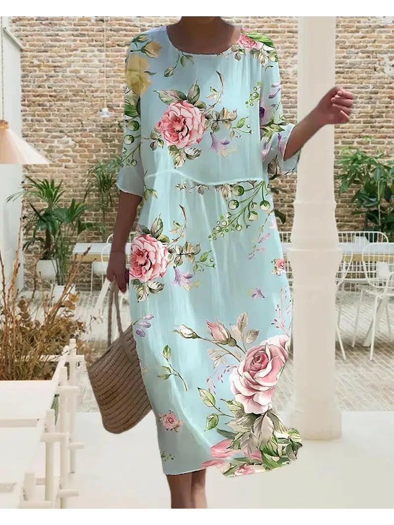 Naia elegant floral dress by Lumina Vancouver, blue color, stylish design with floral pattern, displayed on a dress form.