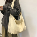 Beige minimalist canvas shoulder bag with oversized design by Lumina Wear, featuring a stylish and spacious hand-held look.