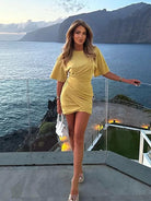 Yellow Fiadh bodycon mini dress with short sleeves from Lumina Vancouver, shown on a model against a neutral background.