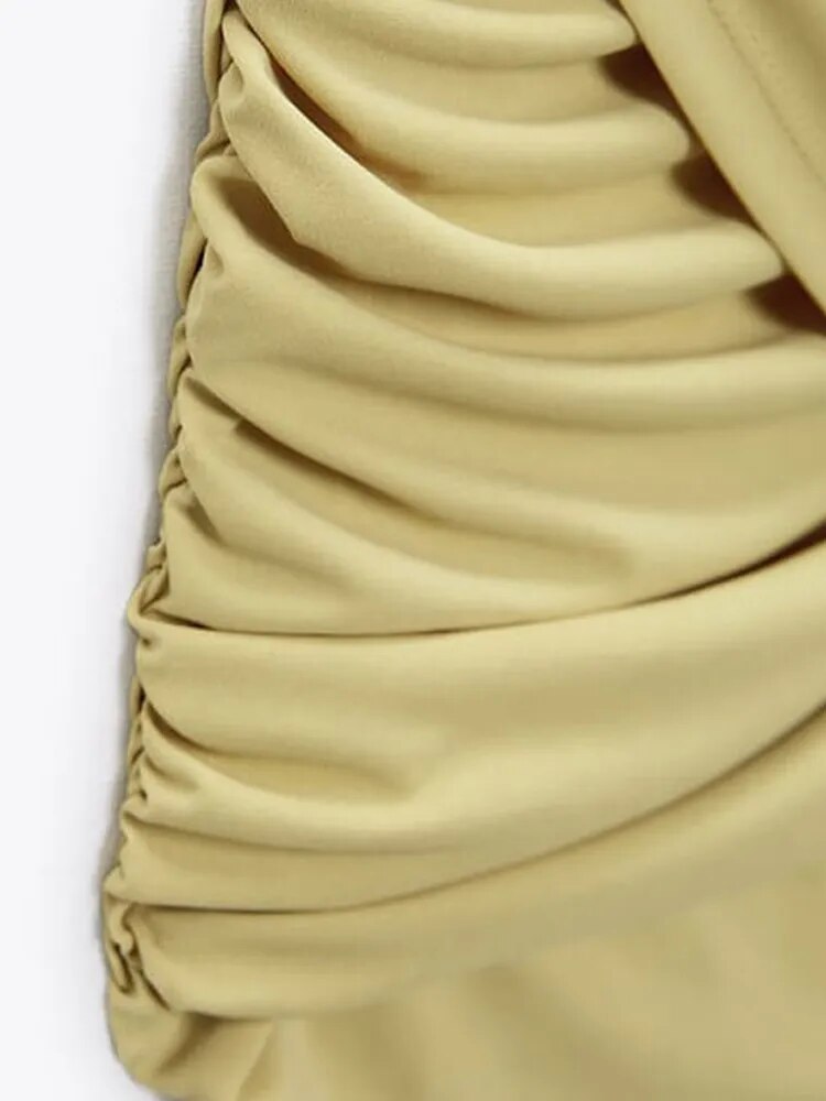 Yellow Fiadh bodycon mini dress with short sleeves by Lumina Vancouver, shown on a model in a casual studio setting.