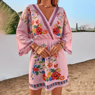 Pink and red floral print V-neck mini dress by Lumina Vancouver, featuring a fitted silhouette and short sleeves.