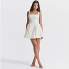 White Quilla mini dress with spaghetti straps from Lumina Vancouver, shown on a model, highlighting its stylish and fitted design.