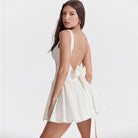 White Quilla mini dress with spaghetti straps from Lumina Vancouver, shown on a model, highlighting its fitted style and delicate straps.