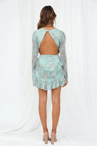 Light green Lumina Vancouver Laurel mini dress with a tiered skirt, fitted bodice, and short sleeves, displayed on a hanger.