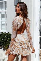Light green Lumina Vancouver Laurel mini dress with a tiered skirt, shown on a model standing outdoors.