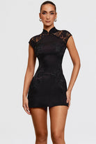 Black satin mini dress with lace embroidery by Lumina Vancouver, showcasing a fitted silhouette and intricate lace details.