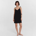 Black Carys satin slip dress by Lumina Wear, mini dress style with smooth satin fabric, shown on a model.