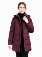 Dark green Olivia Lumina women's longline puffer coat with hood and quilted design, cozy and stylish winter outerwear.