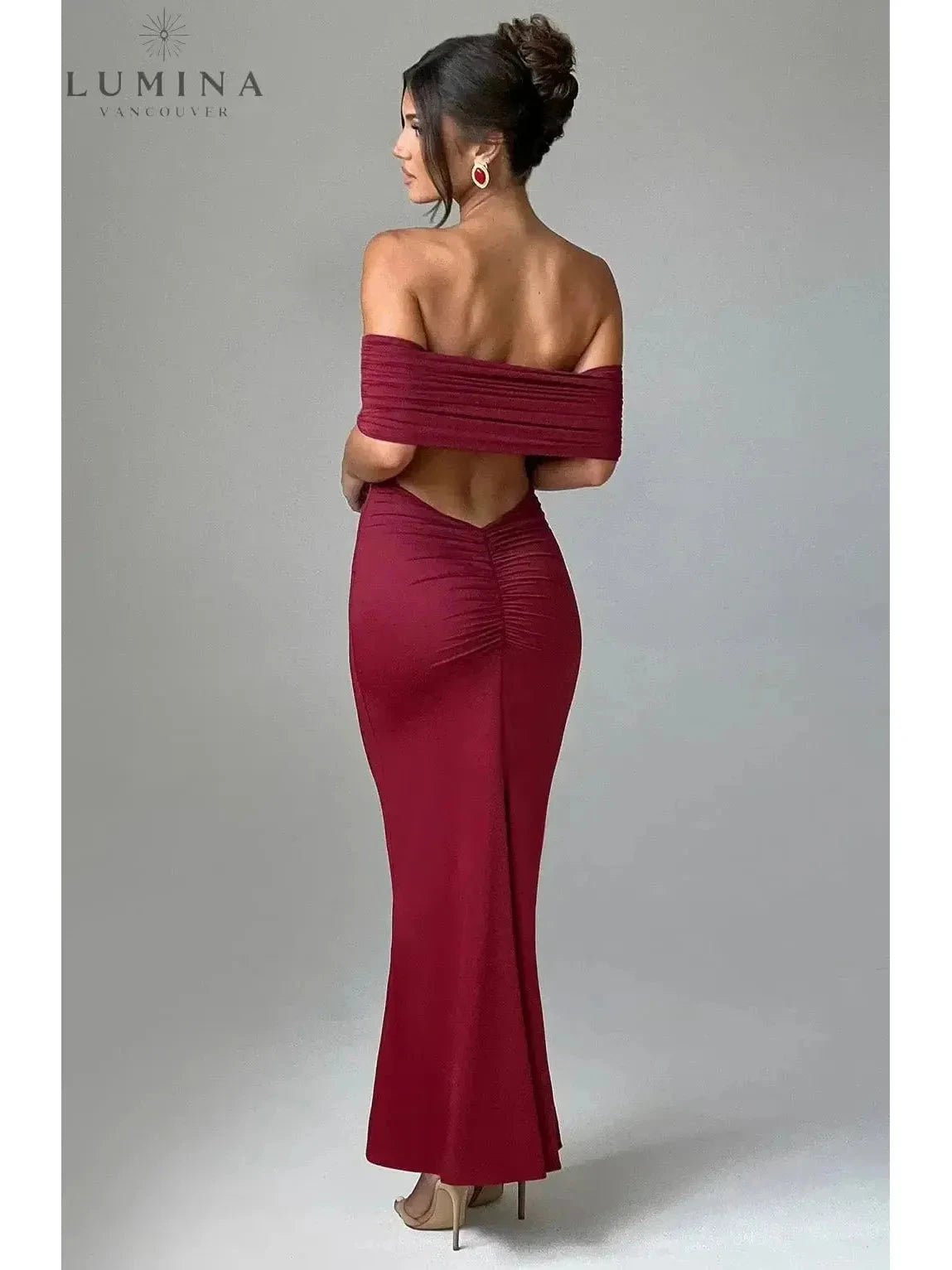 Black Olympia elegant backless maxi dress by Lumina Vancouver, perfect for wedding guest attire, shown on a model.