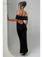 Black Olympia backless maxi dress by Lumina Vancouver, elegant wedding guest gown with flowing silhouette, perfect for formal occasions.