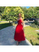 Red Adaline strapless pleated midi dress by Lumina Vancouver, showcasing a sleek design with a fitted bodice and flowing skirt.