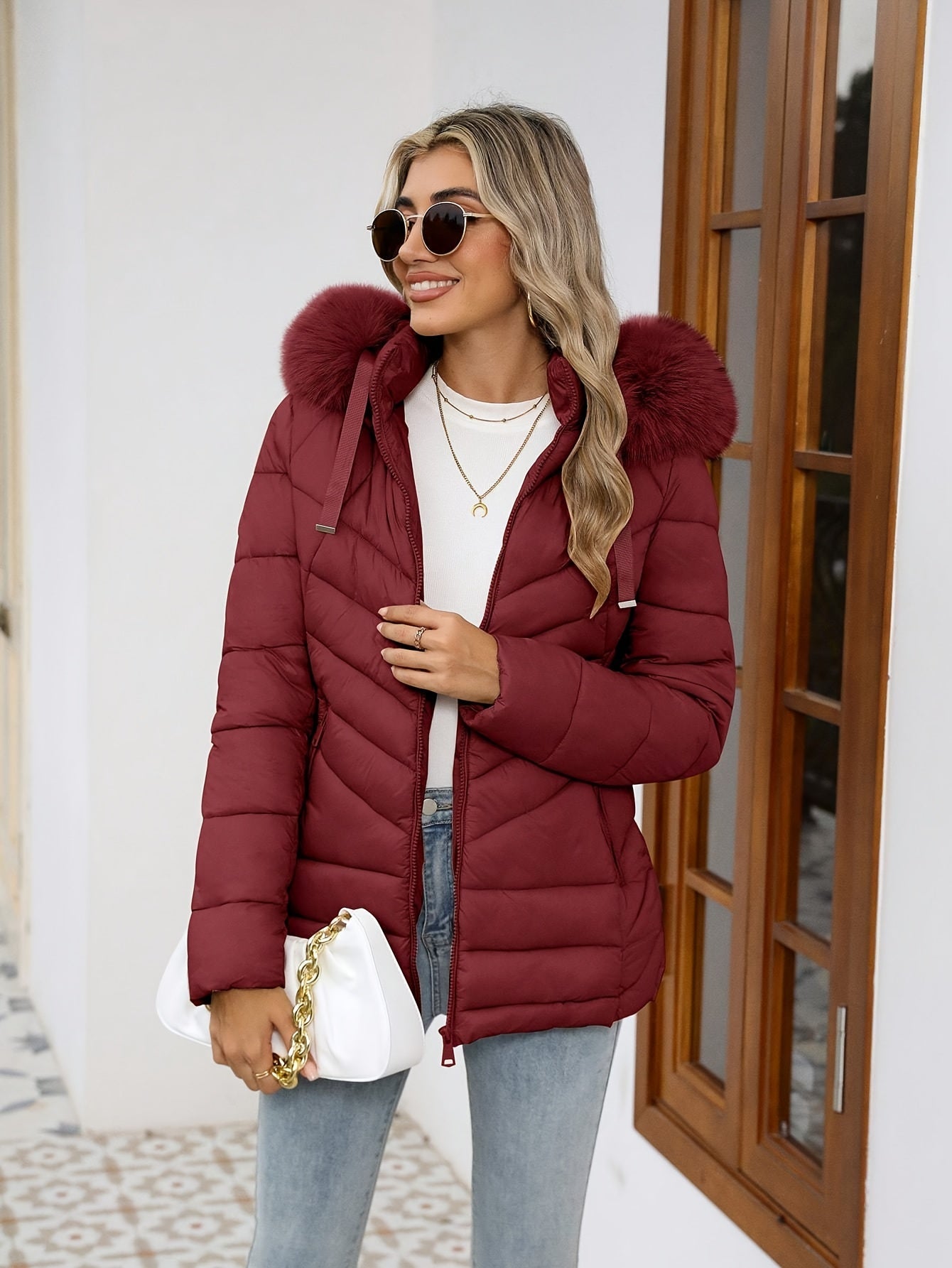 Black women's Ruby quilted puffer jacket with faux-fur hood from Lumina Wear, featuring a cozy, insulated design.