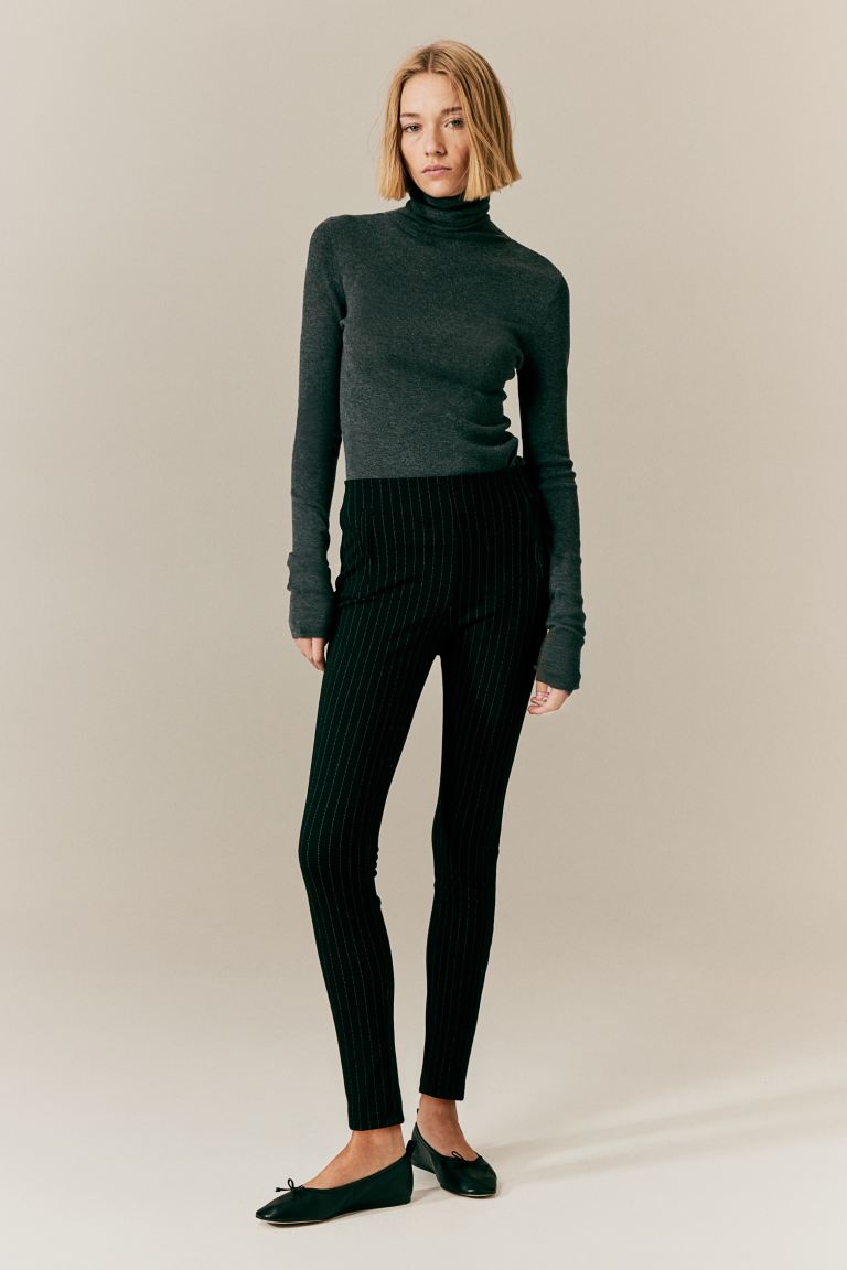 Elegant fitted black trousers with stretch fabric from Lumina Wear, featuring subtle stripe details for a sleek, stylish look.