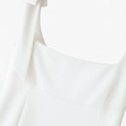 White Sophia bow-detail cami top with zipper closure from Lumina Wear, designed for women, showing front view with bow accents.