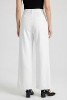 White high-waisted pleated trousers with stretch from Lumina Wear, showcasing elegant, tailored design and comfortable fit.