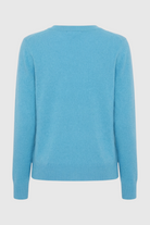 Light blue V-neck women's sweater by Lumina Wear featuring a fitted silhouette and flattering fit, displayed on a model.