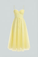 Flowy yellow midi dress from Lumina Wear featuring an elegant design, worn by a model showcasing its stylish silhouette.