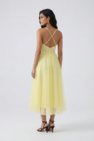 Lumina Wear Sophia yellow midi dress with flowing fabric and elegant design, showcased on a model.