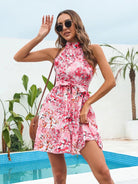 Pink floral halter neck mini dress by Lumina Vancouver, featuring a fitted bodice and short hemline, perfect for summer wear.