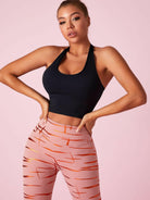 Black Lumina Vancouver sports bra with Roman knot halter design and beautify back detail, ideal for active wear.