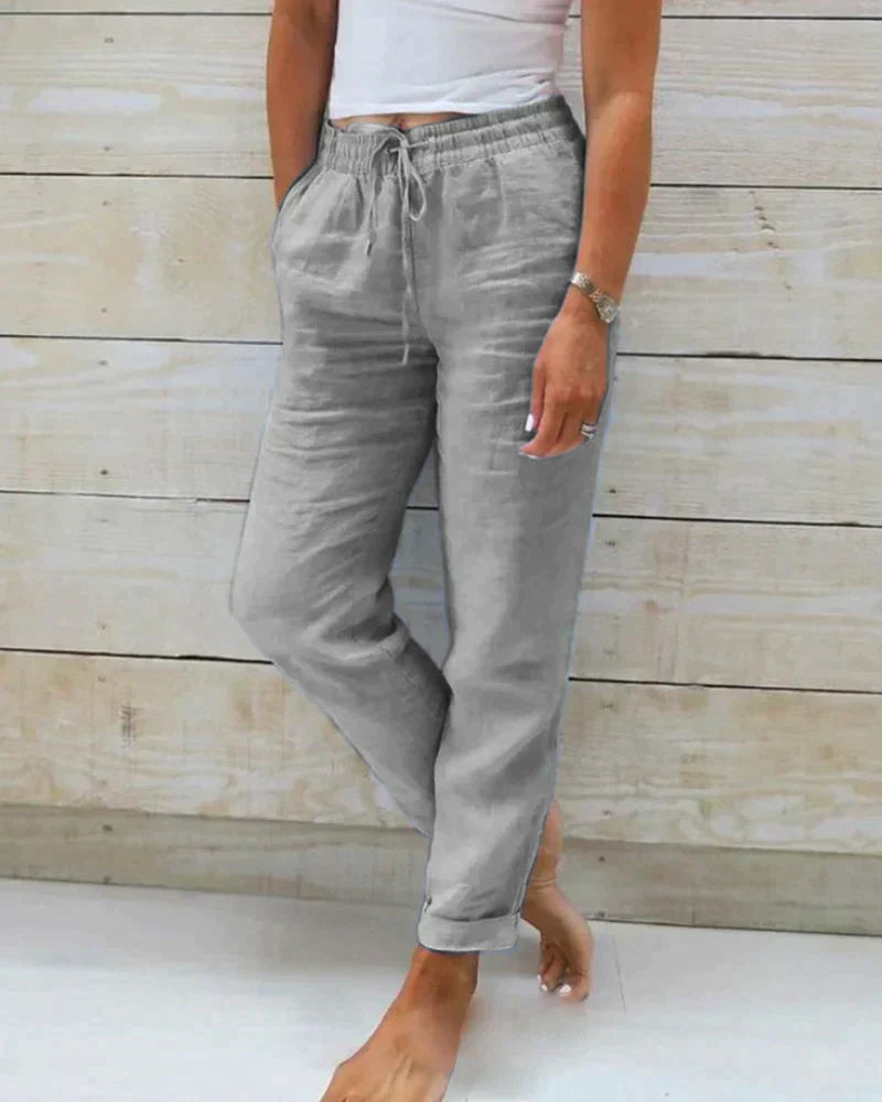 Lightweight beige linen trousers for women with modern fit by Lumina Wear, shown in size XS with a relaxed fit.