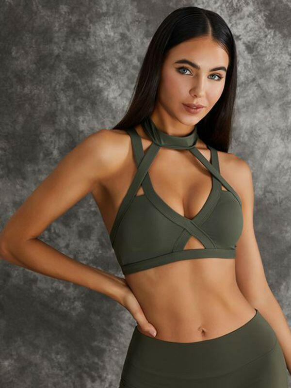 Dark sea green Lumina Vancouver sports bras with unique cut-out design, shown in a stylish bundle.