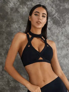 Dark sea green Lumina Vancouver sports bras with unique cut-out design, shown in a bundle of multiple bras.