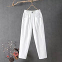 Victoria Lumina white casual trousers with elastic waistband, comfortable pants for relaxed wear, shown in a green background.