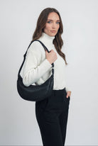 Black Lumina Wear Victoria handbag with adjustable belt and multiple pockets, stylish and functional for everyday use.