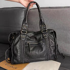 Lumina Wear Victoria black PU leather handbag with multiple pockets, stylish design, and sleek handles for versatile use.