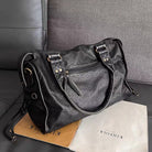 Victoria Lumina black PU leather handbag with multiple pockets, stylish design, and sleek handles for versatile everyday use.