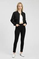 Elegant black bomber jacket from Lumina Wear featuring a timeless design, shown on a model with stylish urban background.