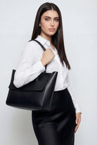Elegant black Lumina Wear handbag with adjustable strap, featuring a sleek design and stylish gold accents.