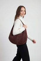 Elegant black suede hobo handbag by Lumina Wear with multiple pockets, featuring a stylish and spacious design.