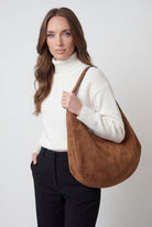 Elegant black suede hobo handbag by Lumina Wear with multiple pockets, showcasing a stylish and functional design.