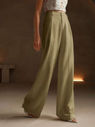 Black Victoria Lumina Wear high-waist wide-leg trousers laid flat, showcasing their elegant fit and tailored design.