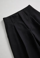 Elegant black high-waisted women's trousers with pleats by Lumina Wear, featuring a tailored fit and classic design.
