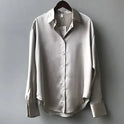 Elegant white button-down blouse by Lumina Wear, relaxed fit with long sleeves and classic collar, styled on a model.