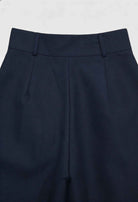 Navy blue Victoria Lumina Wear wide-leg trousers with stretch fabric, shown on a model highlighting their elegant, comfortable fit.