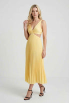 Yellow flowing pleated dress by Lumina Wear, elegant silhouette, women’s dress with a soft, flowing fabric and stylish design.