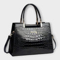 Black Victoria Lumina crocodile pattern handbag with glossy finish and structured design, showcasing elegant craftsmanship.