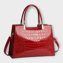 Black Victoria Lumina Wear handbag with glossy crocodile pattern and structured design, stylish and elegant for everyday use.