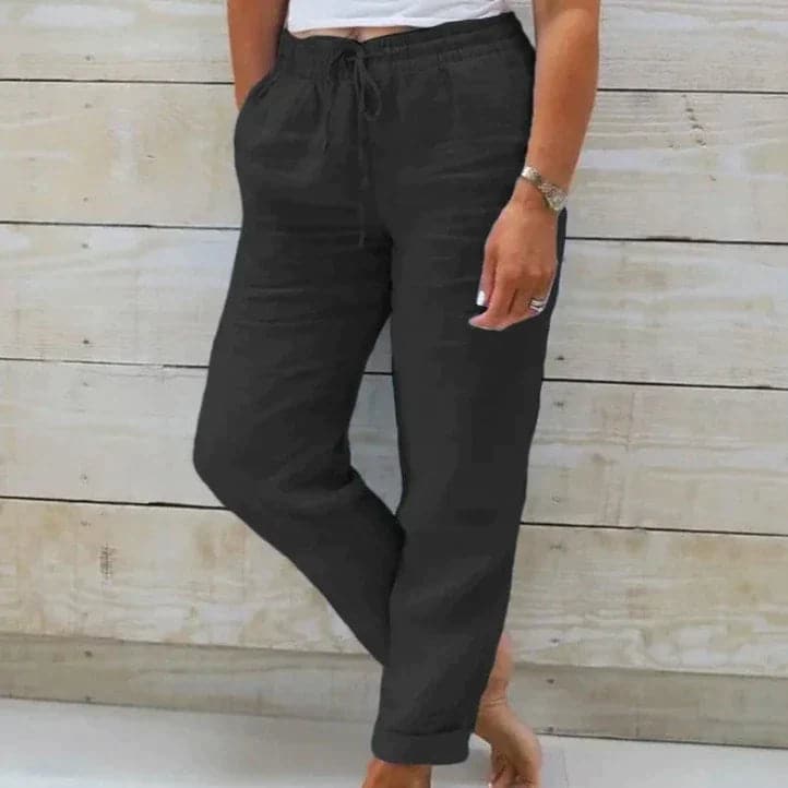 Lightweight beige summer trousers with elastic waist from Lumina Wear, shown flat with open front and relaxed fit.