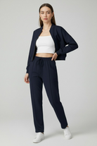 Victoria Lumina activewear set featuring dark blue relaxed fit sweatpants and sweatshirt with zipper accents.